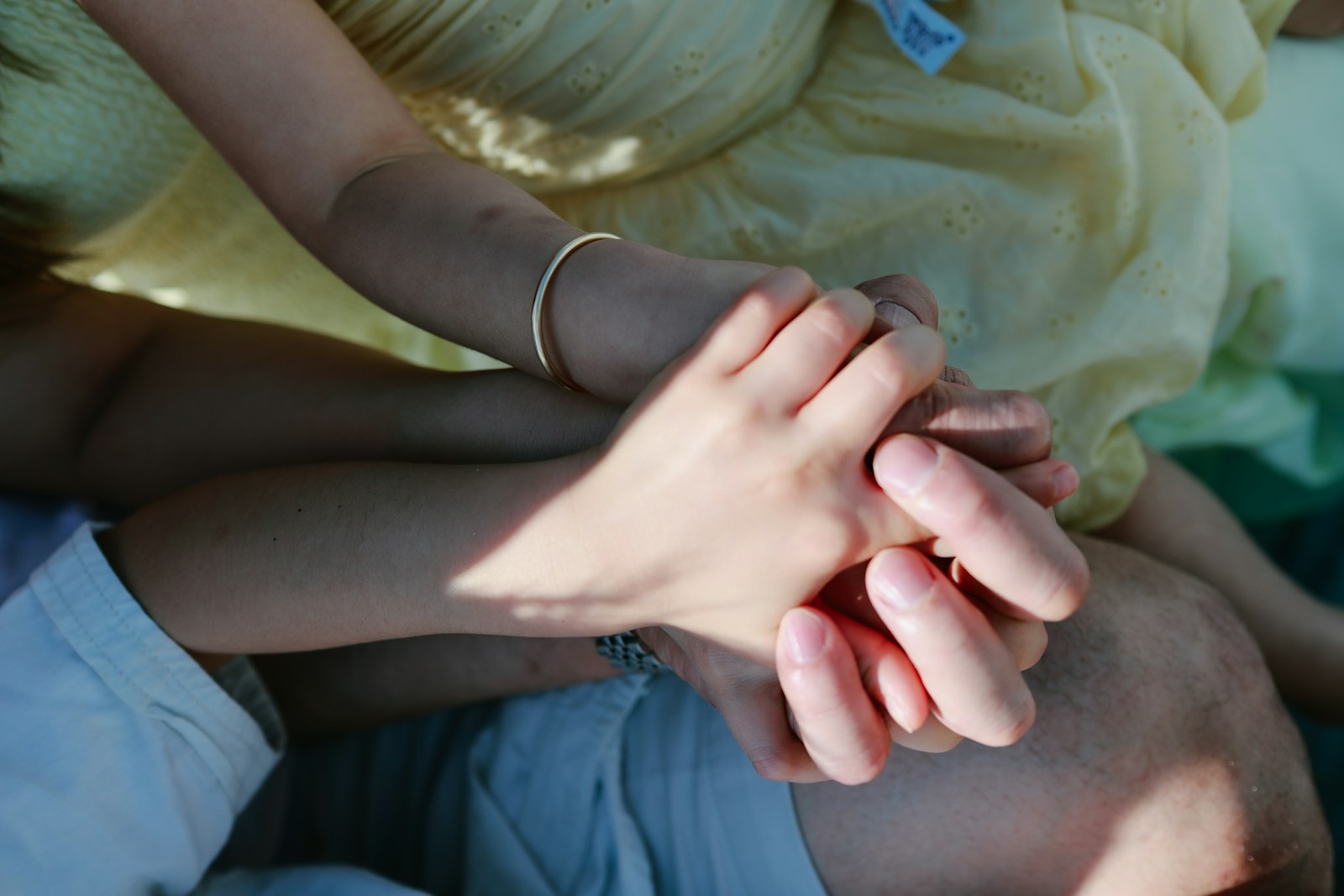 Two people holding hands in sunlight